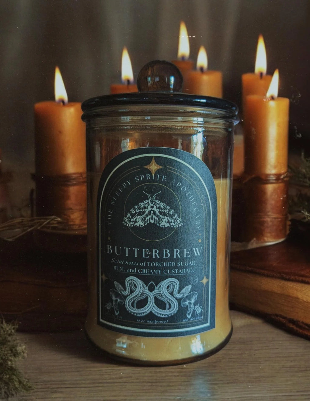  Butterbrew candle jar with lit candles in the background. Harry Potter inspired candle. Witchy dark cottagecore aesthetic.