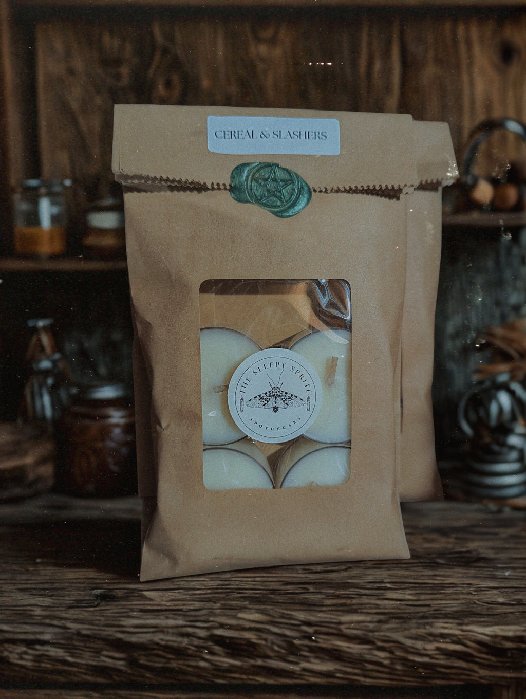 Kraft paper packaging tealight candles with a window displaying white items on a wooden surface. Witchy dark cottagecore aesthetic. Fruit loops scented candle 