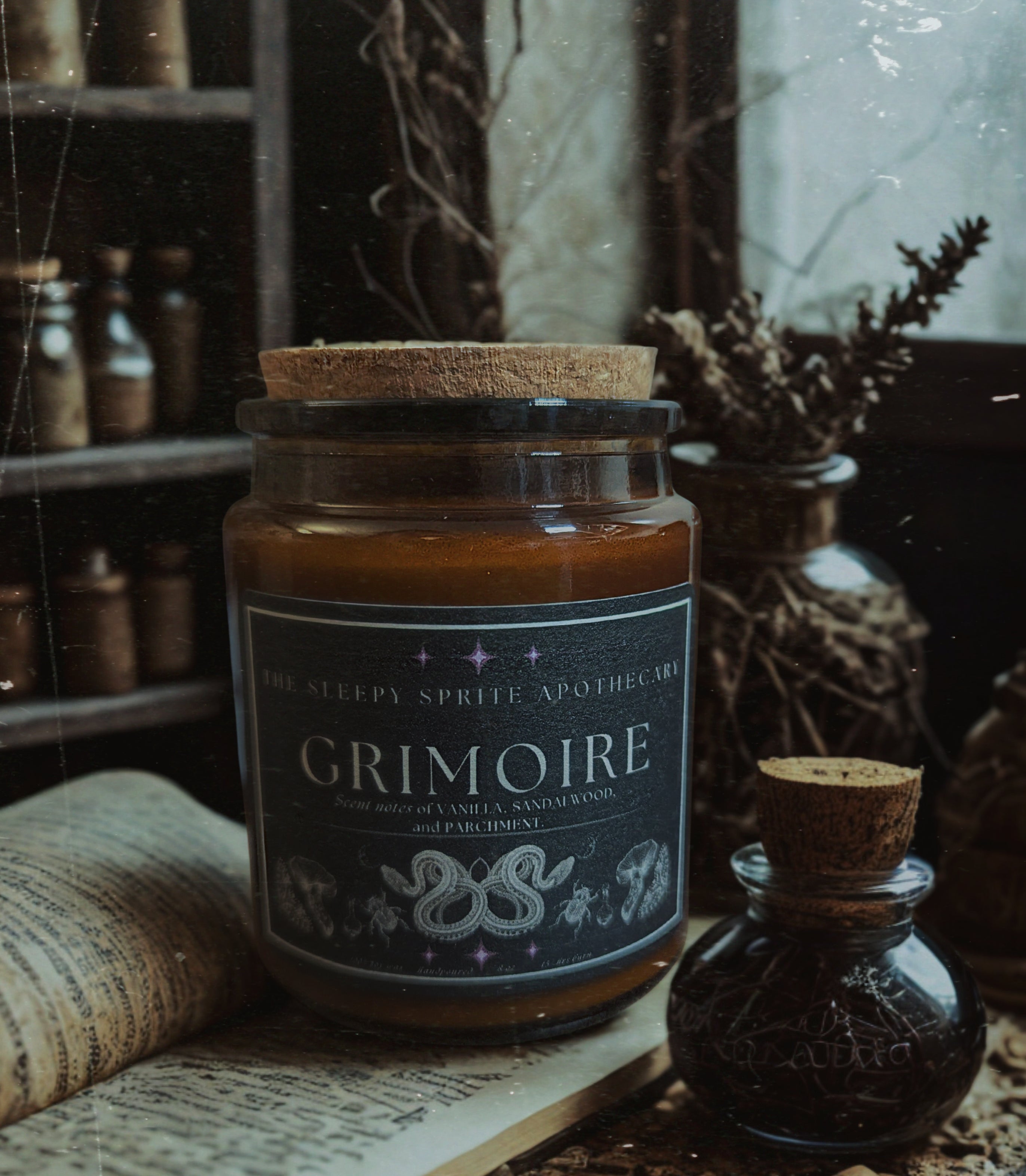 Grimoire candle with decorative label on a rustic background from The Sleepy Sprite Apothecary 